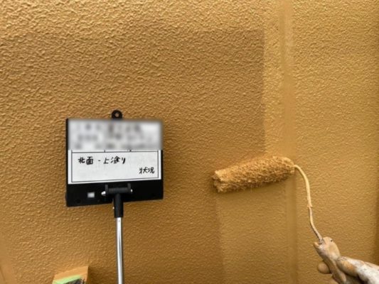 外壁の上塗り塗装（主剤2回目の塗布）｜神奈川県藤沢市の特別養護老人ホームにて塗り替え塗装中