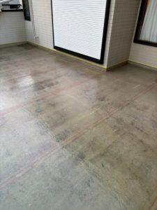 神奈川県平塚市岡崎の戸建て屋上で、ポリエステル樹脂を塗布してガラスマットに含浸させているFRP防水積層工程。防水層を強化中。